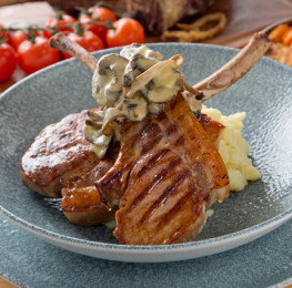 Toms-Table_Chargrilled-double-pork-chop-on-the-bone-crushed-new-potatoes-with-a-wild-mushroom-fricas